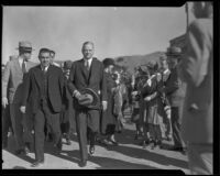 President Herbert Hoover walking at the head of a crowd with Lou Henry Hoover greeting Girl Scouts behind him, Los Angeles (probably), circa 1929-1933