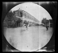 William Sachtleben riding his bicycle in front of the residence of Count Monte-Forte, Tehran, Iran, 1891