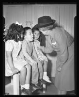 Nurse Cleo E. Thompson examining children, Santa Barbara, 1947