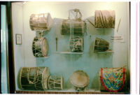 Museum display of ten membranophones, Pune (?) (India), 1984