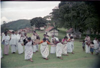 Kota women dance in a line with Kota men musicians playing behind them, Kollimalai (India), 1984