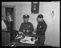 Constable R. E. Foell and Chief of Police Eddie Wiggins examine robbery weapons, El Monte, 1936