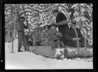 Helen C. Garland, Bertha Garland, William May Garland and Harry Chandler ride in a sled, California, 1936