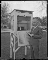 Floyd D. Young, meteorologist, stands outside by a hydrograph, Pomona, 1936