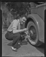 Roscoe Turner, aviator, fixing a car tire, 1935