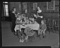 Friday Morning Club members and children gather around a table of toys, Los Angeles, 1935