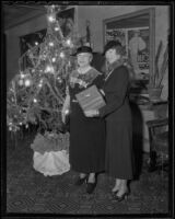 Suzanna Lehmann Philippini and Bessie L. Hewitt next to a Christmas tree in the Ambassador Hotel Theater, Los Angeles, 1935