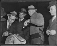 Three men, including Bill Spaulding and James D. Key, read a newspaper, while two other men stand by, Los Angeles, 1935