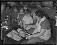 Valerie Lyon bastes a turkey while children watch, Los Angeles, 1935