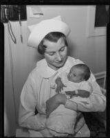 Nurse Amelia Moore holds the first baby born in the hospital on Christmas in Los Angeles, 1935