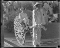 Girl in a rickshaw drawn by a boy next to the "Chinese Empress" float in the Tournament of Roses Parade, Pasadena, 1936