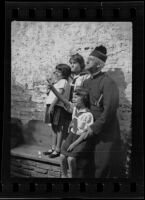 Father Arthur John Hutchinson with some children at Mission San Juan Capistrano, San Juan Capistrano, 1936