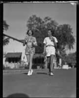 Lucy "Dickey Dell" Doheny and Joyce Hodgeson enjoy ice cream as they walk down a street, Palm Springs, 1936