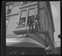 Photographer sets up camera on the awning of a building to capture the arrival of President McKinley, Los Angeles, 1901