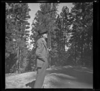 Forrest Whitaker stands among trees holding a pipe, Lake Arrowhead, 1937
