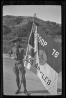 H. H. West Jr. wears a Boy Scouts uniform and holds a flag in Griffith Park, Los Angeles, about 1932