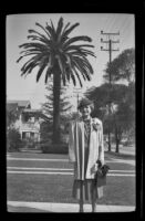 Mertie West poses with a large palm tree in the background, Los Angeles, 1939