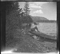 Forrest Whitaker fishes while sitting on a log at Lake Mary, Mammoth Lakes, 1942