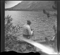 Forrest Whitaker fishes while sitting on a log at Lake Mary Lake, Mammoth Lakes vicinity, 1942