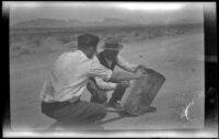 Giles Major and Clarence Cline fixing up a road sign for fellow travelers, Utah or Nevada, 1923