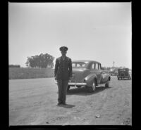 Lynn West poses in front of a car at the entrance of the Air Base where he was stationed, Santa Ana, 1942