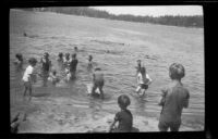 Children swimming on the shore of Lake Arrowhead, circa 1923