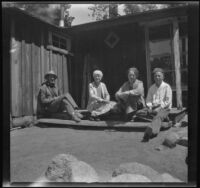 Neil Wells, Mertie West, Frances West Wells and H. H. West, Jr. sit on the Wells' cabin's back porch, Big Bear Lake, 1932