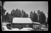 Old log cabin at Minnelusa Canyon, covered in snow, Big Bear, winter 1932
