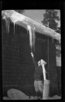 Mertie West after icicles hanging from eaves on the Wells cabin, Big Bear, 1932