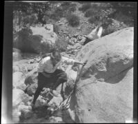 Frances West and Elizabeth West scramble around a boulder near Big Tujunga Creek, Sunland-Tujunga vicinity, 1912