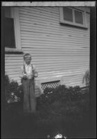 Boy stands next to the West's house at 2223 Griffin Avenue, Los Angeles, about 1932