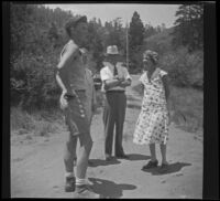 Ed Saxton (Scoutmaster), Agnes Whitaker, Forrest Whitaker and Mertie West stand around in the middle of a dirt road, Big Pines vicinity, 1933