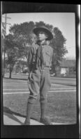 H. H. West Jr. stands in the West's front yard wearing his Boy Scouts uniform, Los Angeles, about 1930