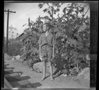 H. H. West, Jr. stands near railroad tracks after taking a test for the Boy Scouts in Sycamore Park, Los Angeles, 1931