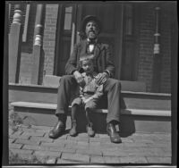 Henry Lemberger and his grandson, Chester Lemberger sit on the steps of a porch, Burlington, 1900