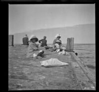 Elizabeth, Frances, and Mary West sit on a pier fishing, Santa Catalina Island, about 1910