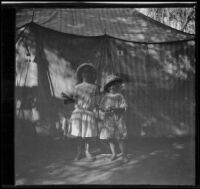 Elizabeth and Frances West stand in front of a tent, Santa Catalina Island, about 1910
