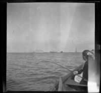 Frances West fishes off the side of a boat, San Pedro vicinity, about 1910