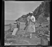 "Cap" Clarence W. Jargstorff holds a shovel and stands amidst debris on the shore, South Catalina Island, 1909
