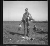 Charlie Stavnow poses with ducks killed on a shoot, Orange County vicinity, about 1912
