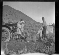 H. H. West holds a string of trout while Elizabeth West, Frances West and Ted McClellan watch, Mammoth Lakes vicinity, 1915