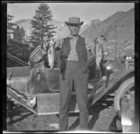 Charlie Stavnow holds two Convict Creek trout, Mammoth Lakes vicinity, 1915