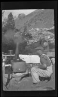 Edward Steinberg looks at a stove near Convict Lake, Mammoth Lakes vicinity, 1918