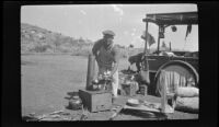 Edward Steinberg holds a pan over the camp stove, Mammoth Lakes vicinity, 1918