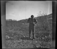 Roger Stearns adjusting his camera to take a picture, Gorman vicinity, circa 1910s