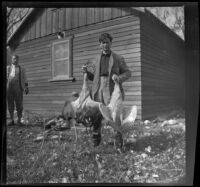 Fred Gilmer poses with 2 sandhill cranes, Gorman vicinity, circa 1910s