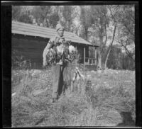 Fred Gilmer poses with ducks outside of the clubhouse, Gorman vicinity, circa 1910s
