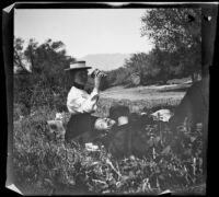 Louise Ambrose and Charlie Rucher relax in the grass near Devils Gate, Pasadena 1899