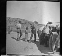 Members of the West, McClellan, Stavnow and Velzy party either load or unload a car, Kern County, about 1915