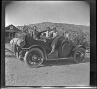 Al Schmitz, Glen Velzy and Wilf Cline pose for a photograph around H. H. West's Buick near Dove Springs, Kern County, about 1917